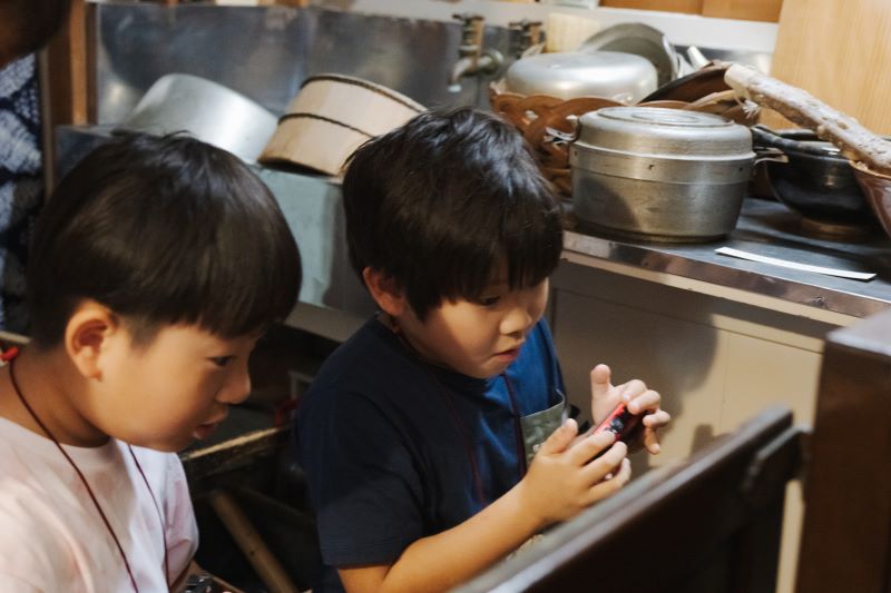 画像：写真を撮る男の子2人
