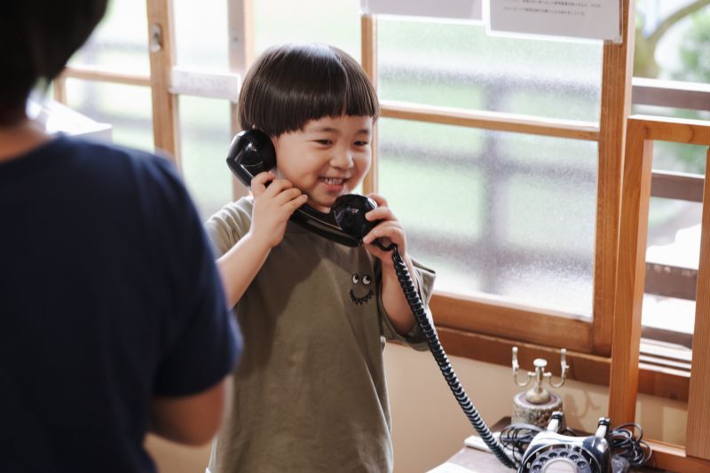 画像：黒電話に出る男の子